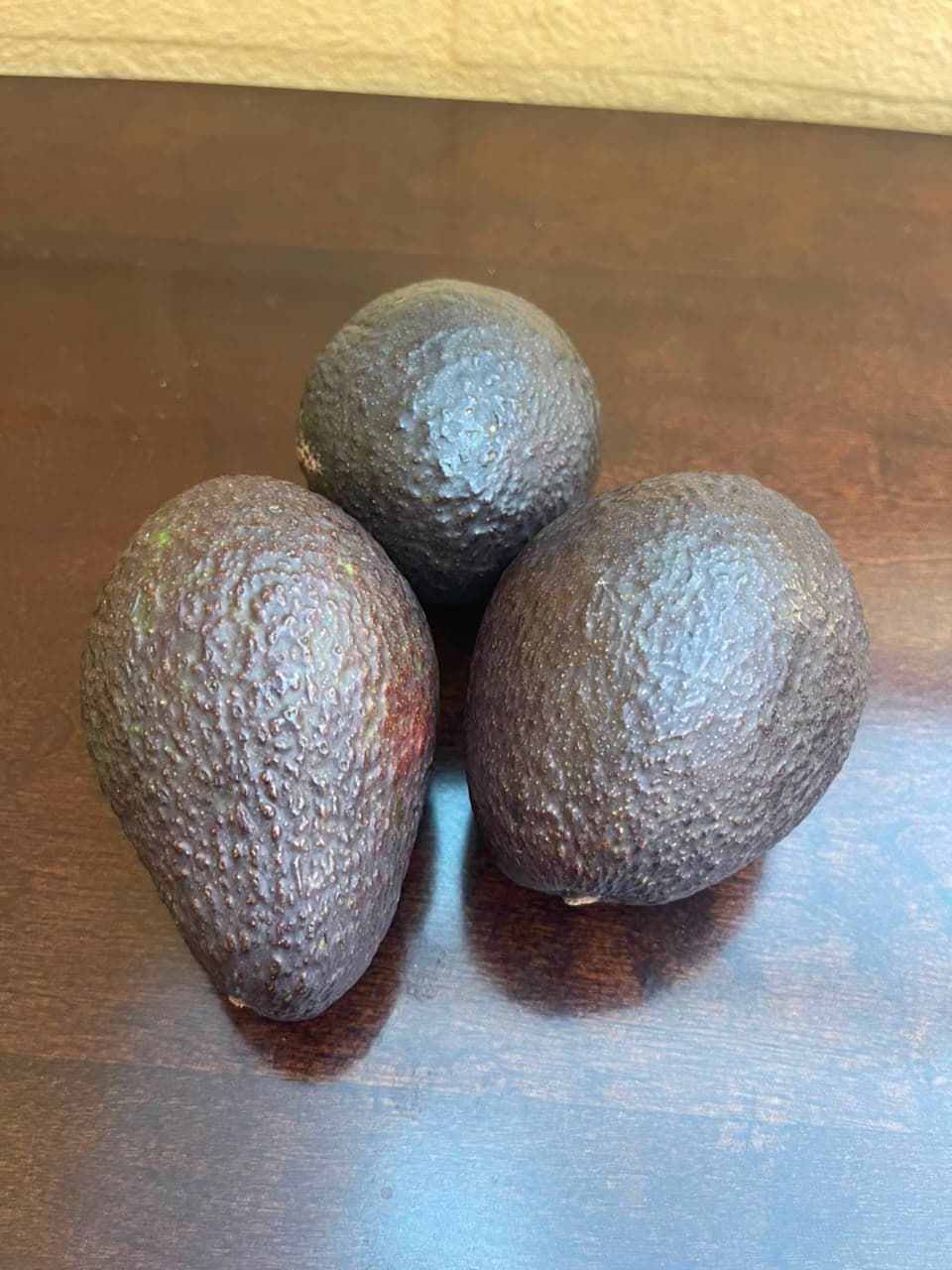 Dos mitades de palta Hass, una con carozo y otra deshuesada